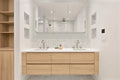Contemporary bathroom with natural wood floating double vanity, marble backsplash, and mirror medicine cabinets